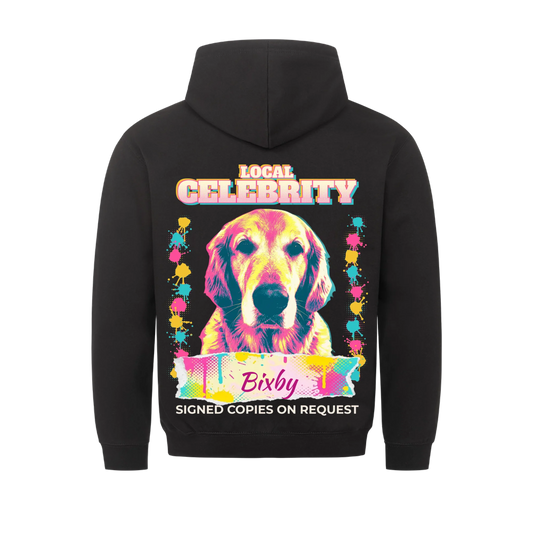 Black hoodie back print: personalized pop-art dog portrait with paint-splatter columns, "Local Celebrity" title, name on a torn splatter banner and "Signed copies on request"