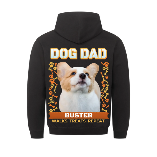 Custom dog dad hoodie, black, back print: the dog's own photo cut out under the title DOG DAD, orange bones and paw prints on both sides, name on a rust ribbon banner, line Walks. Treats. Repeat.