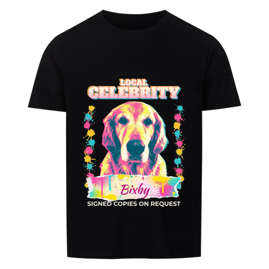 Black T-shirt with a personalized pop-art portrait of a dog in pink, yellow and teal, "Local Celebrity" title above, the dog's name in pink script on a torn paint-splatter banner and "Signed copies on request" below